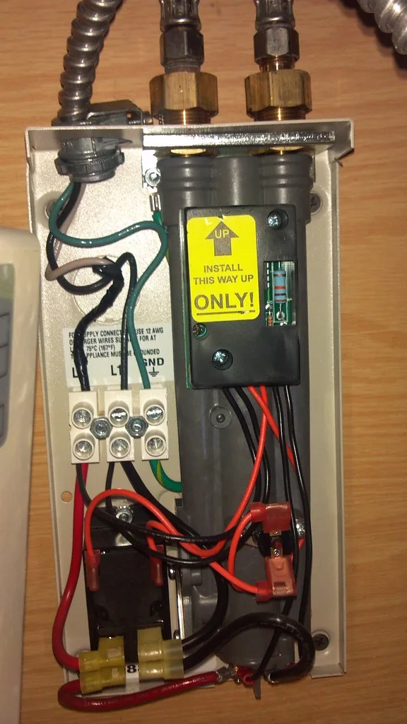 Homeowner checking a water heater control panel in a utility room