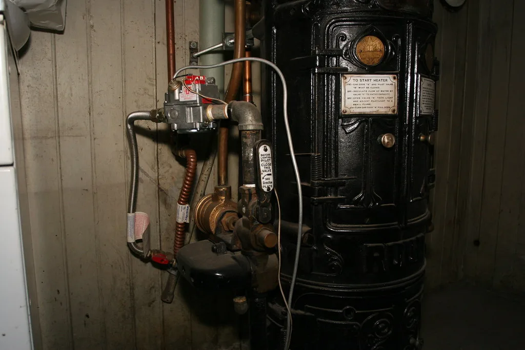 Close-up of a plumber tightening a water heater pipe fitting