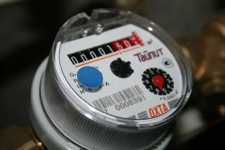 Homeowner reaching for the gas shutoff and water valve on a residential water heater